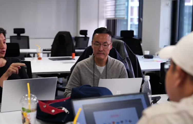 A person sitting at a table with laptopsAI-generated content may be incorrect.