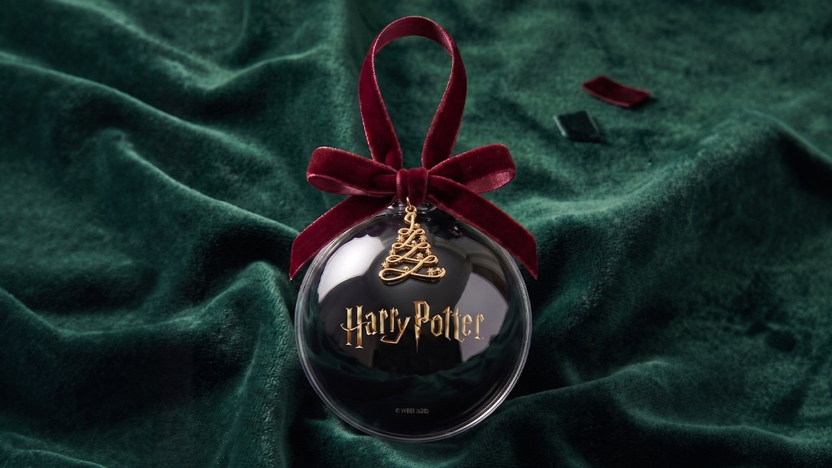 The J.Dot Memorable Ornament, an officially licensed Harry Potter digital ornament, resting on dark green fabric with the Harry Potter logo on its screen